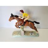 Beswick Girl with yellow jumper jumping fence on brown horse