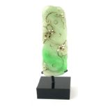 A CHINESE CARVED PALE JADE EXOTIC FRUIT Lychee in a pierced design, on a black perspex base.