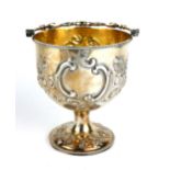 A VICTORIAN SILVER BONBON BASKET Having a swing handle with embossed floral decoration and gilt