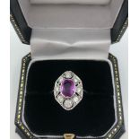 AN 18CT WHITE GOLD ART DECO STYLE RING set with oval pink sapphire surrounded by diamonds size N
