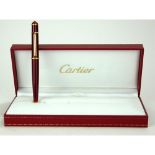 CARTIER, A CASED FULL SIZE GOLD PLATED STYLO DIABOLO BALLPOINT PEN Bordeaux finish with cabochon cut