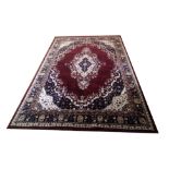 A LARGE INDIAN PLUSH VELVET RUG OF CARPET PROPORTIONS The central floral field on a wine red