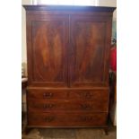 A GEORGE III PERIOD MAHOGANY LINEN PRESS With flame mahogany oval panelled doors enclosing slides