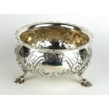 A VICTORIAN SILVER THREE FOOTED SUGAR BOWL Having scrolled rim with embossed floral decoration and