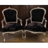 A PAIR OF FRENCH DESIGN SPOONBACK OPEN ARMCHAIRS With silvered frames upholstered in black button