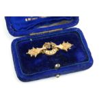 AN EDWARDIAN 9CT GOLD AND SEED PEARL BAR BROOCH Having three pearls forming a lucky horseshoe, in