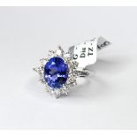 AN 18CT WHITE GOLD, TANZANITE AND DIAMOND CLUSTER RING The single oval cut tanzanite stone edged