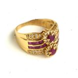 A VINTAGE 18CT GOLD, RUBY AND DIAMOND RING The arrangement of oval and square cut rubies edged