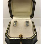 A PAIR OF 18CT GOLD STUD EARRINGS set with emerald cut aquamarines .8 cm