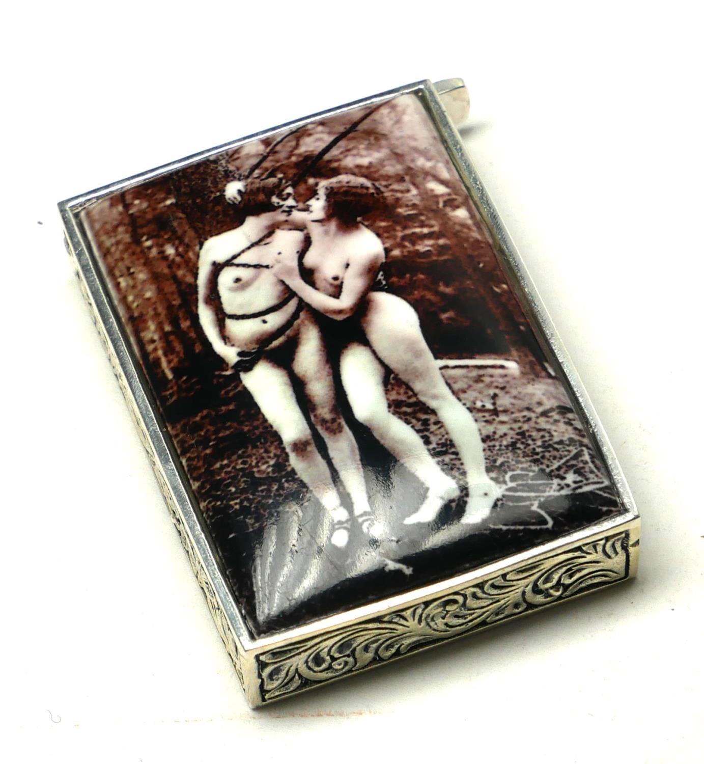 A CONTINENTAL SILVER AND ENAMEL 'EROTIC' VESTA CASE Having a photographic sepia tone image of two