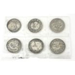 A COLLECTION OF SIX CHINESE WHITE METAL MEDALLION COINS Various designs including a five toe