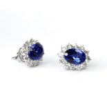 A PAIR OF 18CT WHITE GOLD, TANZANITE AND DIAMOND STUD EARRINGS Each set with an oval cut tanzanite