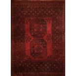 A BOKHARA WOOLLEN RUG With two octagonal designs to central field, on a red ground within running