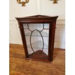 A GEORGIAN DESIGN MAHOGANY WALL HANGING CORNER CABINET With a single glazed door enclosing a silk