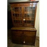 A GEORGIAN OAK AND MAHOGANY BOOKCASE With two glazed doors above two drawers and cupboards. (118cm x