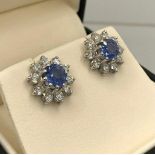 A PAIR OF 18CT WHITE GOLD FLORAL EARRINGS central set with natural cornflower blue sapphires