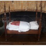 A MAHOGANY FOUR POSTER DOLLS BED With mattress, quilts and pillows. (57cm x 33cm x 60cm)