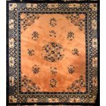 A LARGE CHINESE WOOLLEN RUG The floral central field on peach ground within running borders. (approx