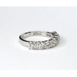 AN 18CT WHITE GOLD AND DIAMOND SEVEN STONE HALF ETERNITY RING The single row of round cut