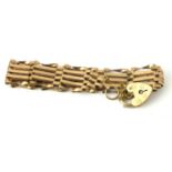 A 20TH CENTURY 9CT GOLD GATE BRACELET Having pierced links with heart form clasp. (approx length