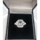 AN 18CT WHITE GOLD ART DECO STYLE RING set with .80ct aquamarine surrounded by diamonds size O