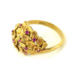 A VINTAGE 18CT GOLD AND RUBY CLUSTER RING The arrangement of round cut rubies in an organic