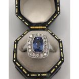 AN 18CT WHITE GOLD ART DECO STYLE RING set with 1.50ct sapphire surrounded by .55ct diamonds