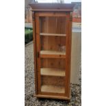 A CONTINENTAL PINE DISPLAY CABINET With a single glazed door enclosing shelves. (69cm x 41cm x