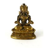 A LATE 18TH/EARLY 19TH CENTURY CHINESE GILT BRONZE FIGURE OF GUANYIN Seated pose clutching a vessel,