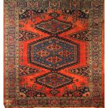 A PERSIAN SHIRAZ WOOLLEN RUG Having three lozenge form designs to central field and three running
