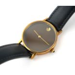 MOVADO, A VINTAGE YELLOW METAL 'MUSEUM' GENT'S WRISTWATCH Having a burgundy tone dial with