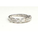 AN 18CT WHITE GOLD AND DIAMOND SEVEN STONE RING The single row of round cut diamonds (size O). (