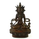 A CHINESE TIBETAN BRONZE FEMALE DEITY STATUE Seated pose holding a Dorji on lotus base. (approx