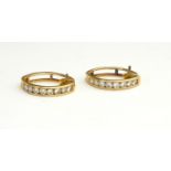 A PAIR OF YELLOW METAL AND DIAMOND EARRINGS Semicircular hoops set with round cut diamonds. (