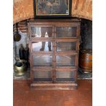 AN EARLY 20TH CENTURY OAK BARRISTER FOUR SECTION BOOKCASE With glazed doors and beaded design to