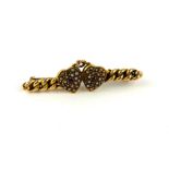 A VICTORIAN YELLOW METAL, RUBY AND SEED PEARL BAR BROOCH Two hearts set with a single ruby with seed