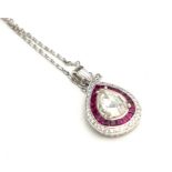 AN 18CT WHITE GOLD DIAMOND AND RUBY PENDANT NECKLACE The central pear cut diamond edged with
