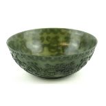 AN ORIENTAL DARK GREEN CARVED JADE BOWL Finely carved with floral swags and scrolls. (approx
