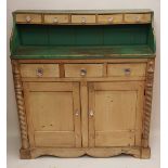 A VICTORIAN WAXED PINE AND PAINTED DRESSER Having an arrangement of drawers with glass handles,