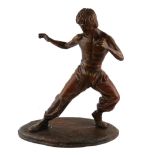 A CONTEMPORARY BRONZE STATUE OF THE MARTIAL ARTS ACTOR BRUCE LEE Striking pose on oval base. (approx
