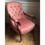 A VICTORIAN MAHOGANY OPEN ARMCHAIR Button back floral upholstery on cerise ground, raised on