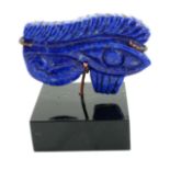 A CARVED LAPIS LAZULI EGYPTIAN EYE PLAQUE On black perspex stand. (approx 7cm x 4cm)