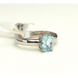 AN 18CT WHITE GOLD AND BLUE TOPAZ SOLITAIRE RING The oval cut pale blue topaz in a plain white