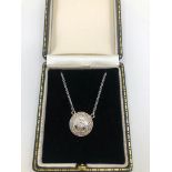 AN 18CT WHITE GOLD AND DIAMOND HALO PENDANT. (diamond approx 0.70ct)