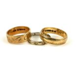 TWO VINTAGE 9CT GOLD WEDDING BANDS With engraved decoration, together with a white metal and wide
