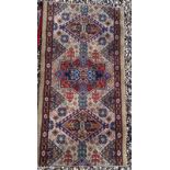 A COLLECTION OF THREE PERSIAN WOOLLEN RUGS Having geometric motifs on a red and brown field. (