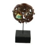 A CHINESE RUSSETT JADE DRAGON CARVING Spherical scrolled and pierced design, on an ebonised wood