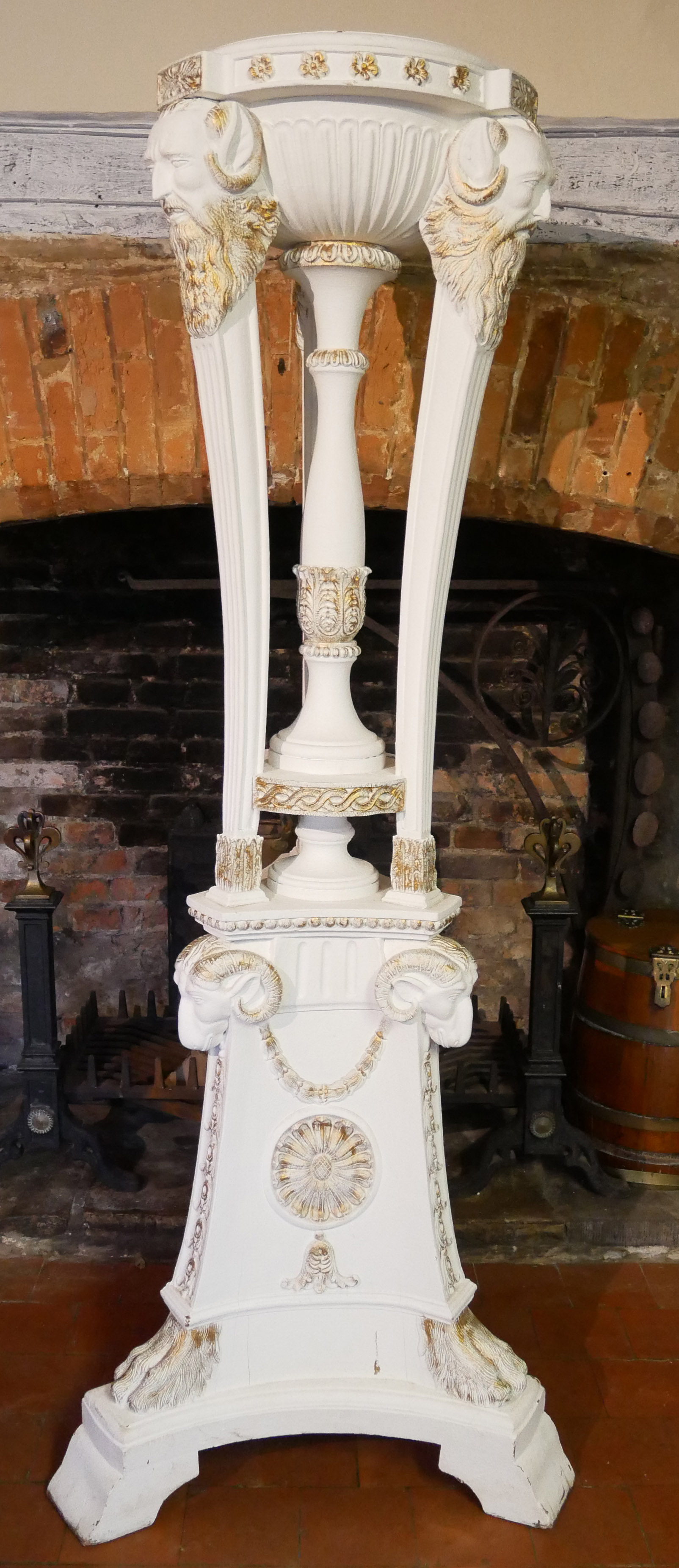 A LARGE CLASSICAL STYLE WOODEN TORCHERE Later white painted and gilt highlighted finish carved