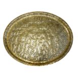 A LARGE INDIAN BRASS FIGURAL OVAL CHARGER With an embossed and fine hand chased battle scene of '