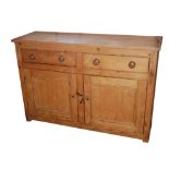 A VICTORIAN WAX PINE DRESSER BASE With two drawers above panel doors opening to reveal a shelved